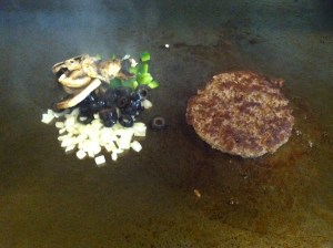 After flipping burger.  Score patty to evenly cook.  Saute onions, mushrooms, olives and bell peppers. 