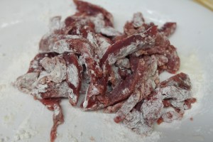 Slice beef against the grain into thin strips.  Coat with cornstarch.