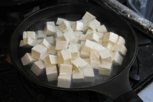 Bring a pot of water to boil and add tofu.  This firms the tofu so it doesn't break when stir frying.
