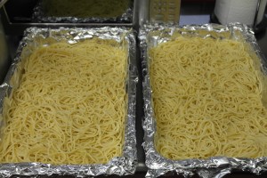 Cook 4 bags of spaghetti al dente and divide into hotel pans.