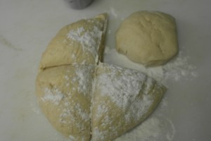 Knead and add butter.  Form a ball and allow to double in size.  Punch down and divide into four.