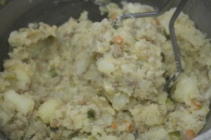 Add meat and vegetables and continue to mash and mix.