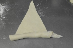 Roll triangles from the widest point to the tip.