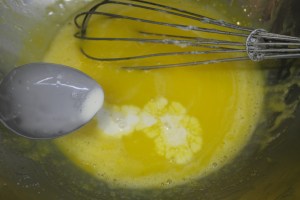 Temper eggs with cream.  Continually whisk to avoid scrambling.