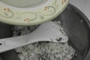 Using back of spatula pour over rice.