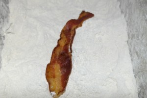 Dredge bacon in flour. Tap off excess.